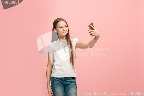 Image of The happy teen girl making selfie photo by mobile phone