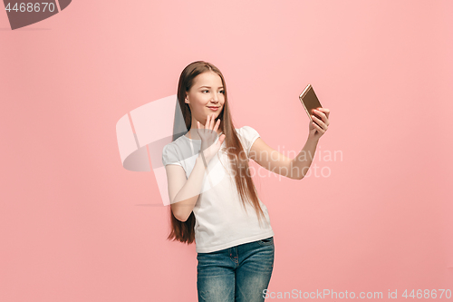 Image of The happy teen girl making selfie photo by mobile phone