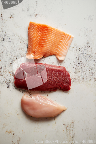 Image of Fresh raw beef steak, chicken breast, and salmon fillet