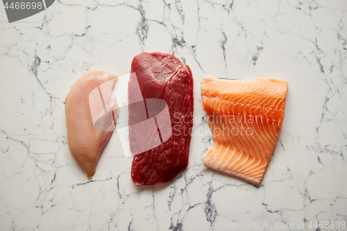 Image of Fresh raw beef steak, chicken breast, and salmon fillet