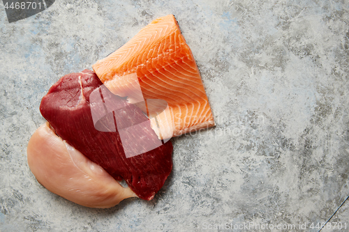 Image of Fresh raw beef steak, chicken breast, and salmon fillet