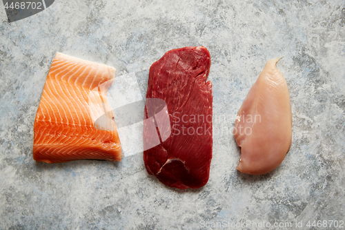 Image of Fresh raw beef steak, chicken breast, and salmon fillet