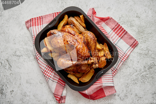 Image of Roasted chicken or turkey with potatoes in black steel mold