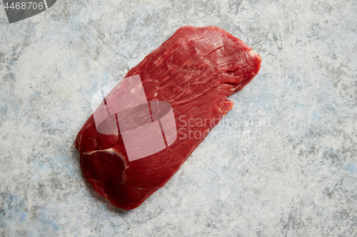 Image of Piece of raw fresh beef steak placed on gray stone background