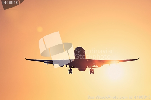 Image of Airplane landing at sunset