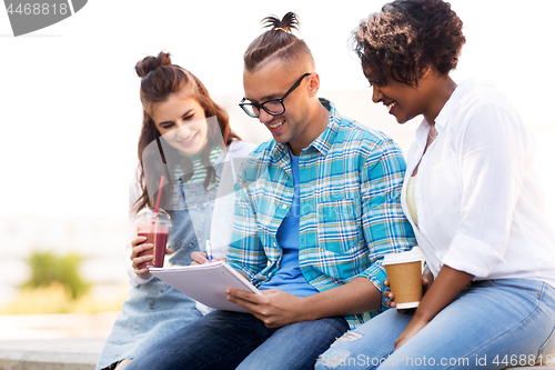 Image of students with notebook and takeaway drinks