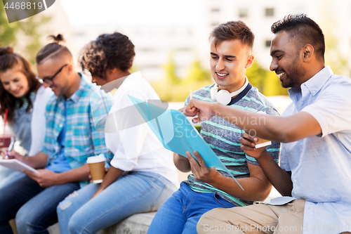 Image of students with notebook and takeaway drinks