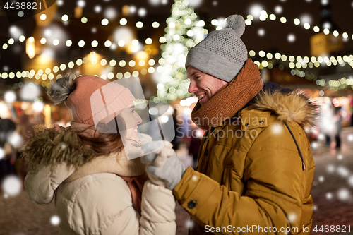 Image of happy couple holding hands at christmas tree