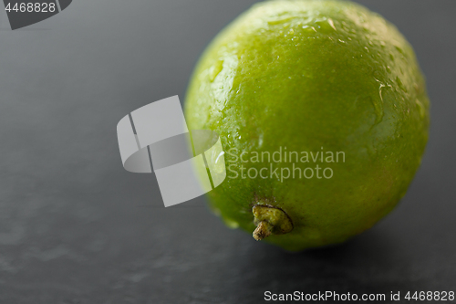 Image of close up of whole lime on slate table top