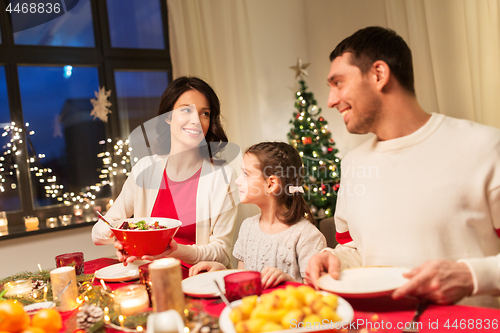 Image of happy family having christmas dinner at home