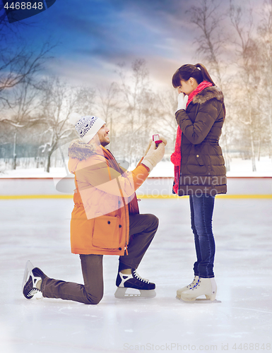 Image of man with ring making proposal on skating rink