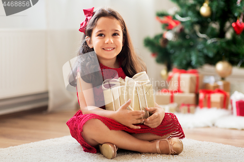 Image of happy girl with christmas gift at home