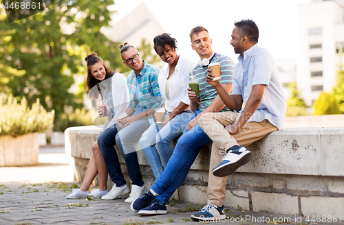 Image of friends drinking coffee and juice talking in city