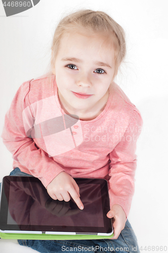 Image of Little girl uses a tablet PC