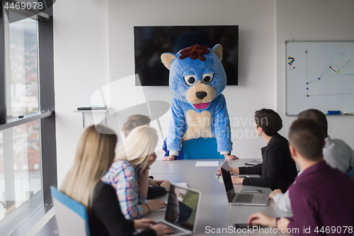 Image of boss dresed as bear having fun with business people in trendy of