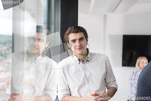 Image of young businessman in startup office by the window