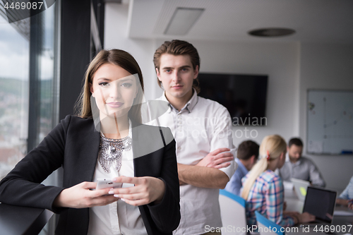 Image of Elegant Woman Using Mobile Phone by window in office building