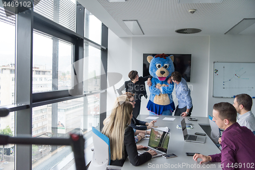 Image of boss dresed as bear having fun with business people in trendy of