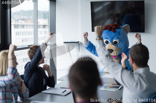 Image of boss dresed as bear having fun with business people in trendy of