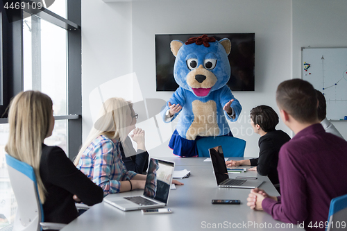 Image of boss dresed as bear having fun with business people in trendy of