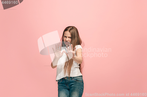 Image of Doubtful pensive teen girl rejecting something against pink background