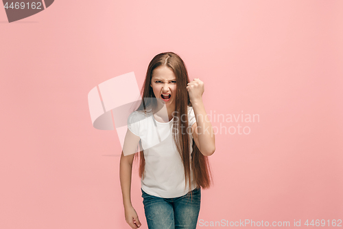 Image of Portrait of angry teen girl on a pink studio background