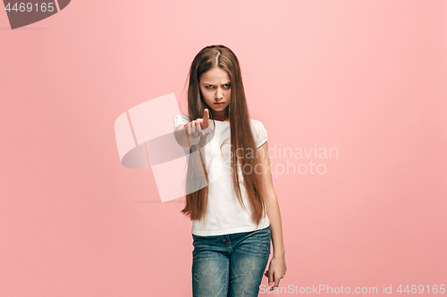 Image of The teen girl pointing to you, half length closeup portrait on pink background.