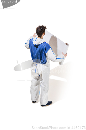 Image of Young male decorator painting with a poster climbed a ladder isolated on white background.