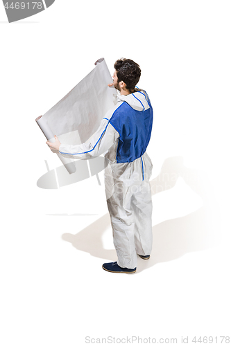 Image of Young male decorator painting with a poster climbed a ladder isolated on white background.