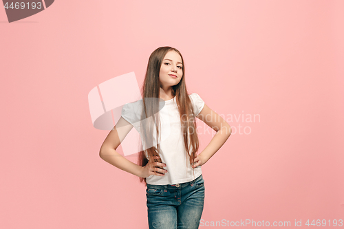 Image of The happy teen girl standing and smiling against pink background.