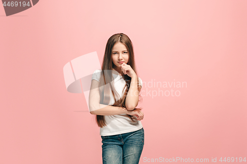 Image of The happy teen girl standing and smiling against pink background.