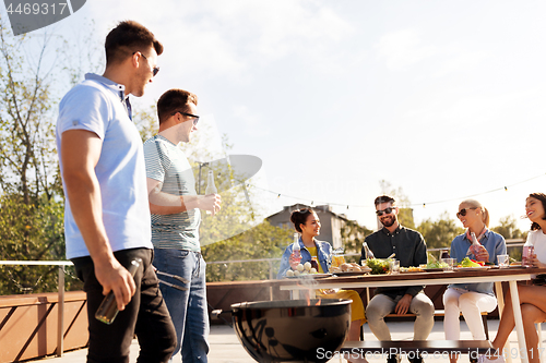 Image of happy friends having bbq party on rooftop