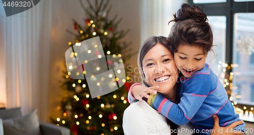 Image of happy mother hugging her daughter on christmas