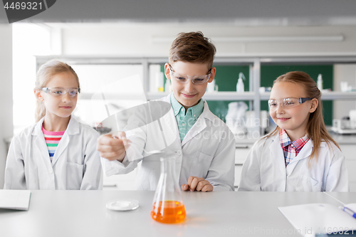 Image of kids with test tube studying chemistry at school