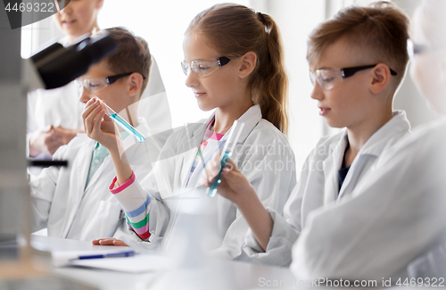 Image of teacher and students studying chemistry at school