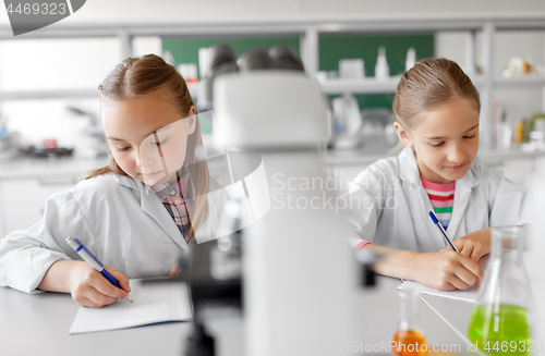 Image of two girls studying chemistry at school laboratory