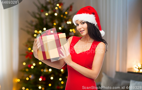 Image of beautiful woman with christmas gift at home