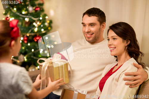 Image of happy family with christmas present at home