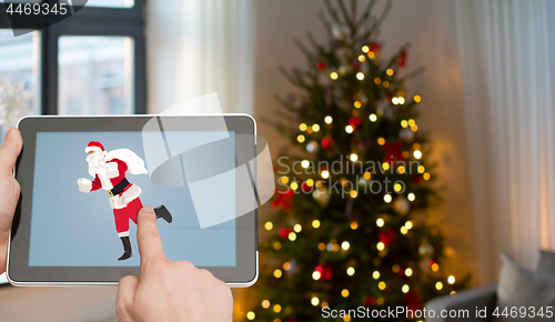 Image of hands with santa image on tablet pc screen