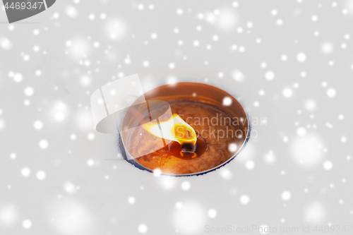 Image of christmas outdoor candle burning on snow in winter