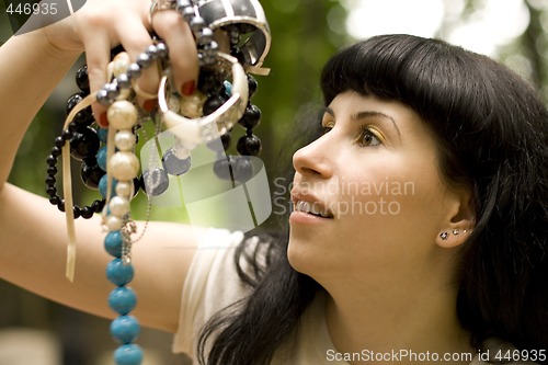Image of brunette holding a lot of beads