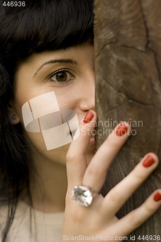 Image of girl hiding behind a tree