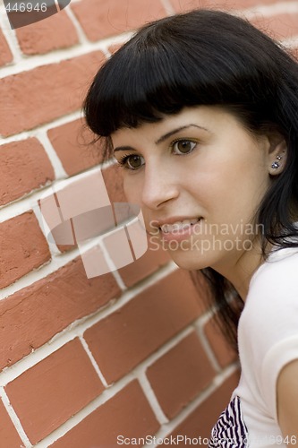 Image of girl against brick wall