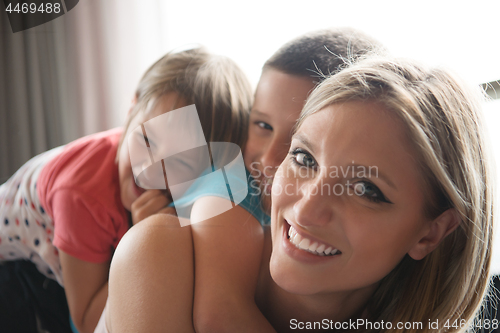 Image of young mother spending time with kids on the floor