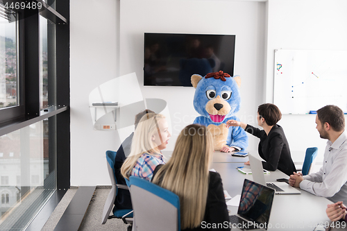 Image of boss dresed as bear having fun with business people in trendy of