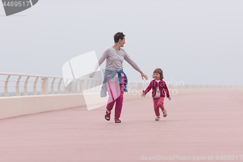 Image of mother and cute little girl on the promenade by the sea