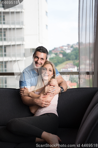 Image of young handsome couple hugging on the sofa