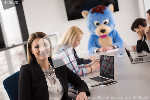 Image of boss dresed as bear having fun with business people in trendy of