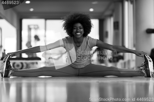 Image of woman in a gym stretching and warming up before workout