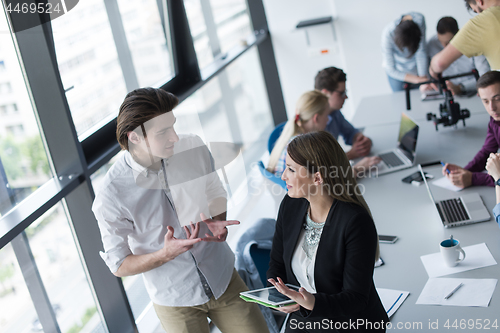 Image of Two Business People Working With Tablet in office